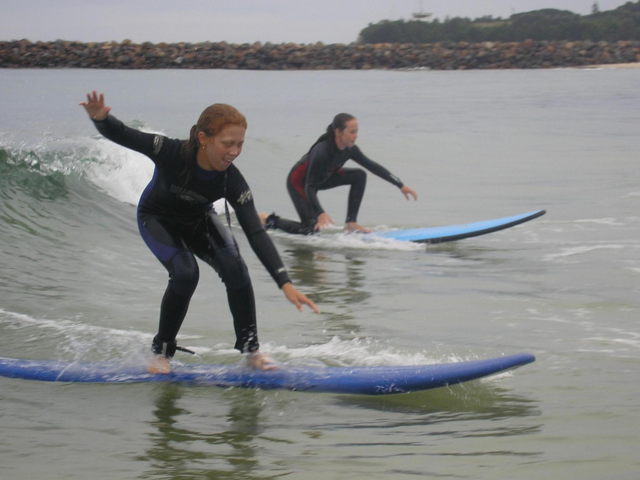2 young girls doing surfing lessons