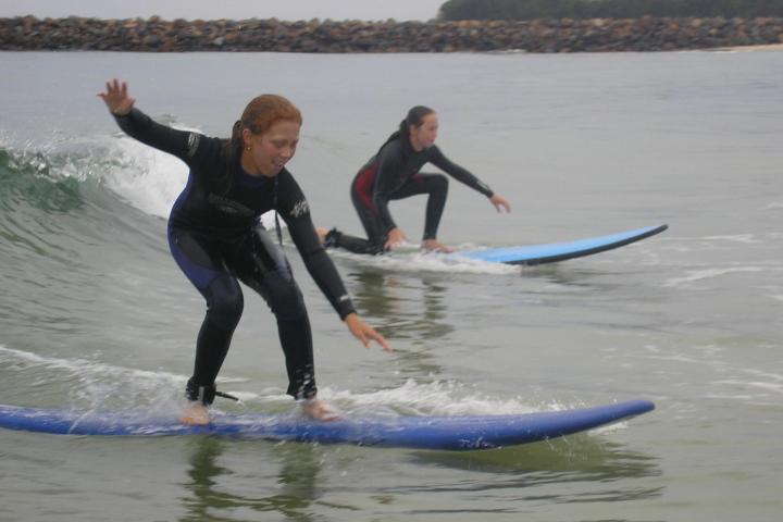 2 young girls doing surfing lessons