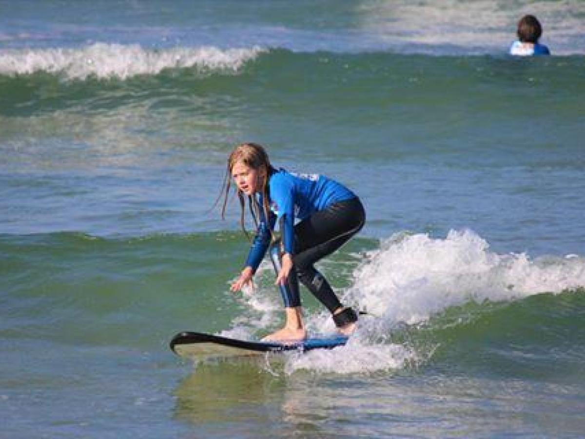 Teenage girl surfing on the beach